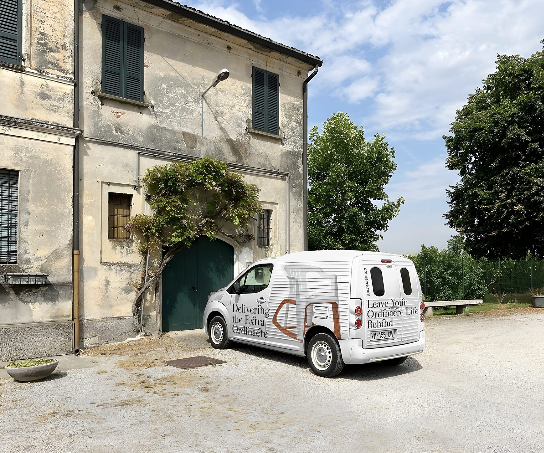 A white ORDINAERE delivery van printed with the chair, parked in front of an old Italian farmhouse