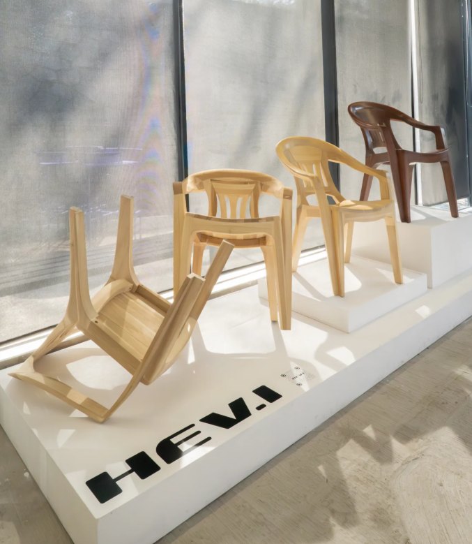 HEV.I's wooden monobloc chairs on a white plinth printed with the HEV.I name